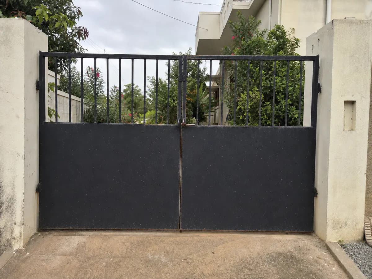 Illustrative metal entrance gate with flaking paint and light rust before painting