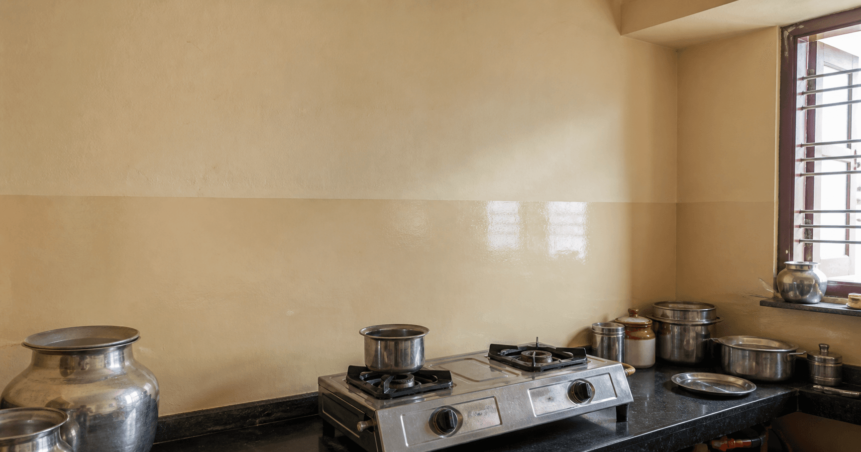 A kitchen wall in satin meeting a gloss splash strip behind the stove
